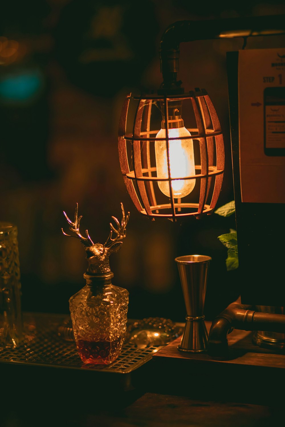 Lampada marrone e nera accesa accanto a un vaso di vetro trasparente
