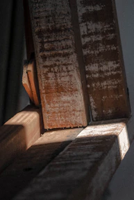 Close-up of skilled hands restoring natural wood beams with fine tools in a luxury lake home.