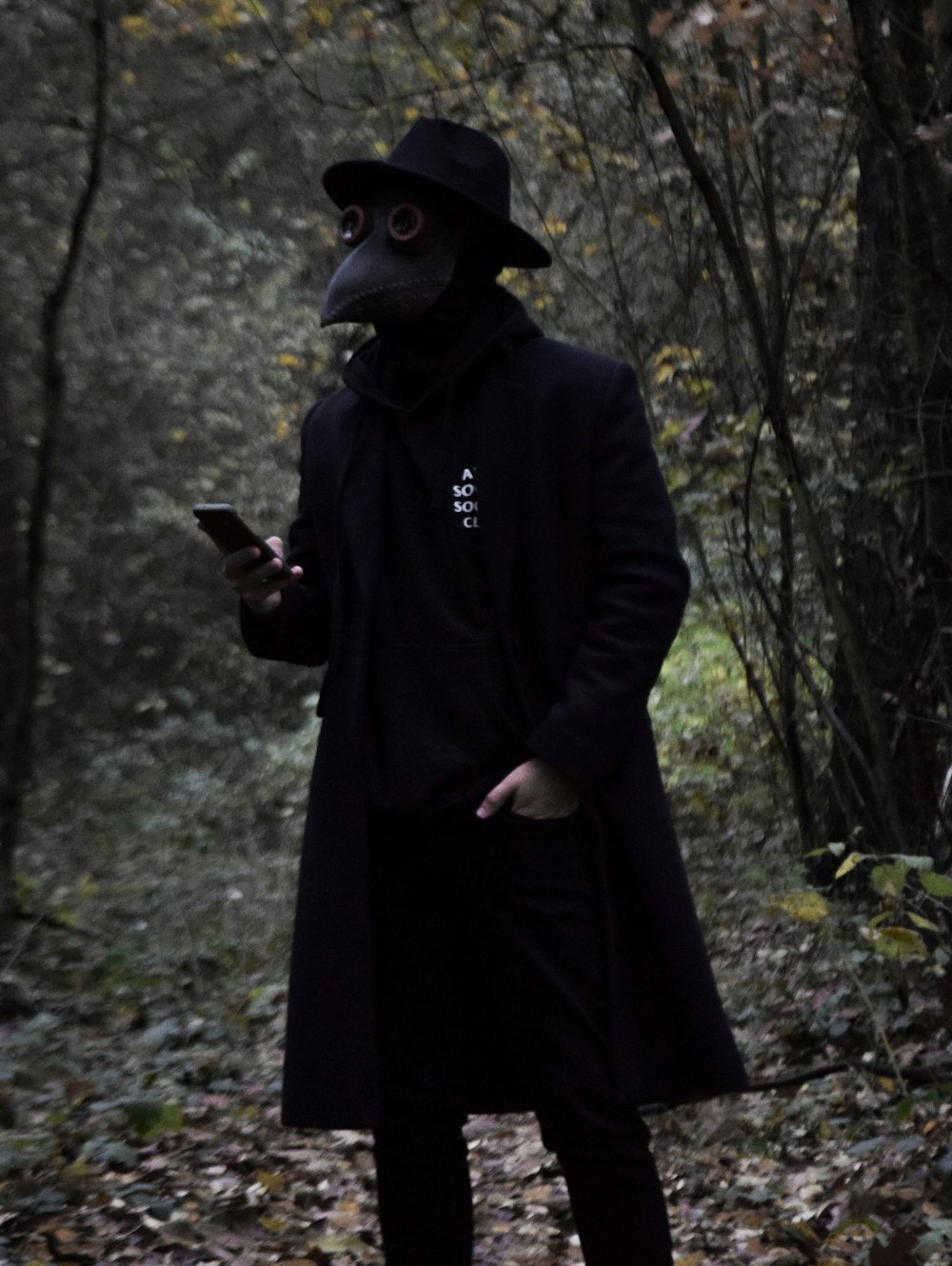 person in black coat holding black smartphone