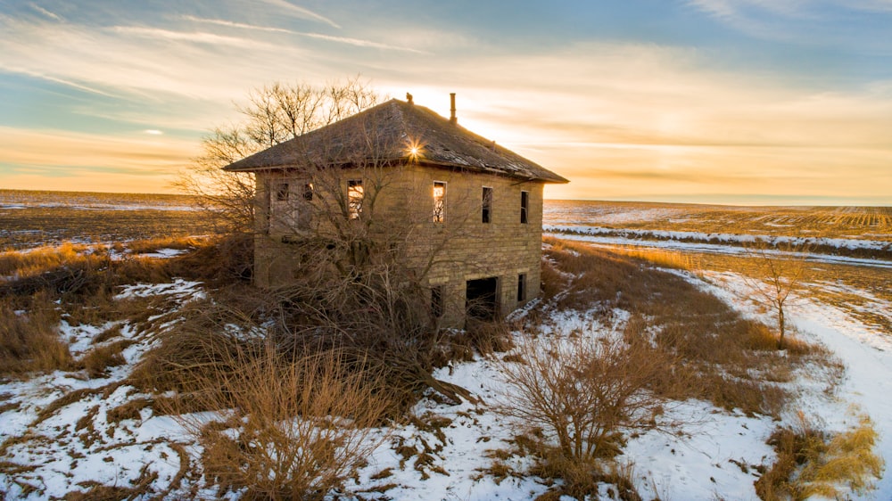 brown wooden house on snow covered ground during daytime