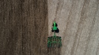 person in green jacket riding green and blue shopping cart