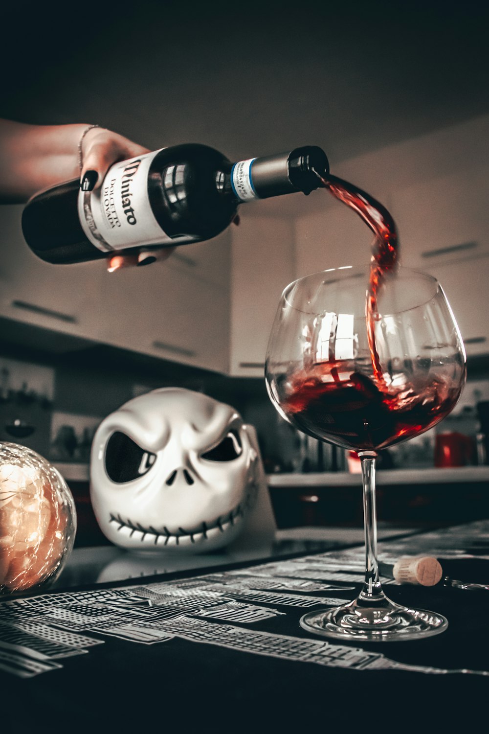 white and black skull with wine glass on table