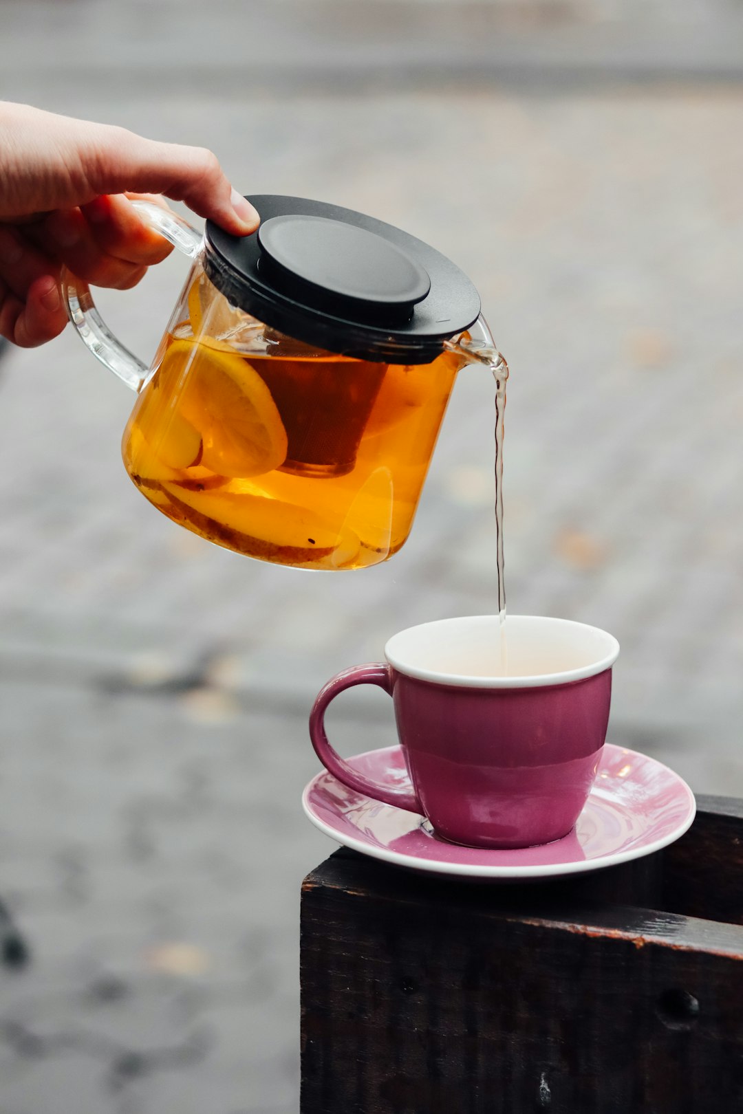 person pouring coffee on pink ceramic mug