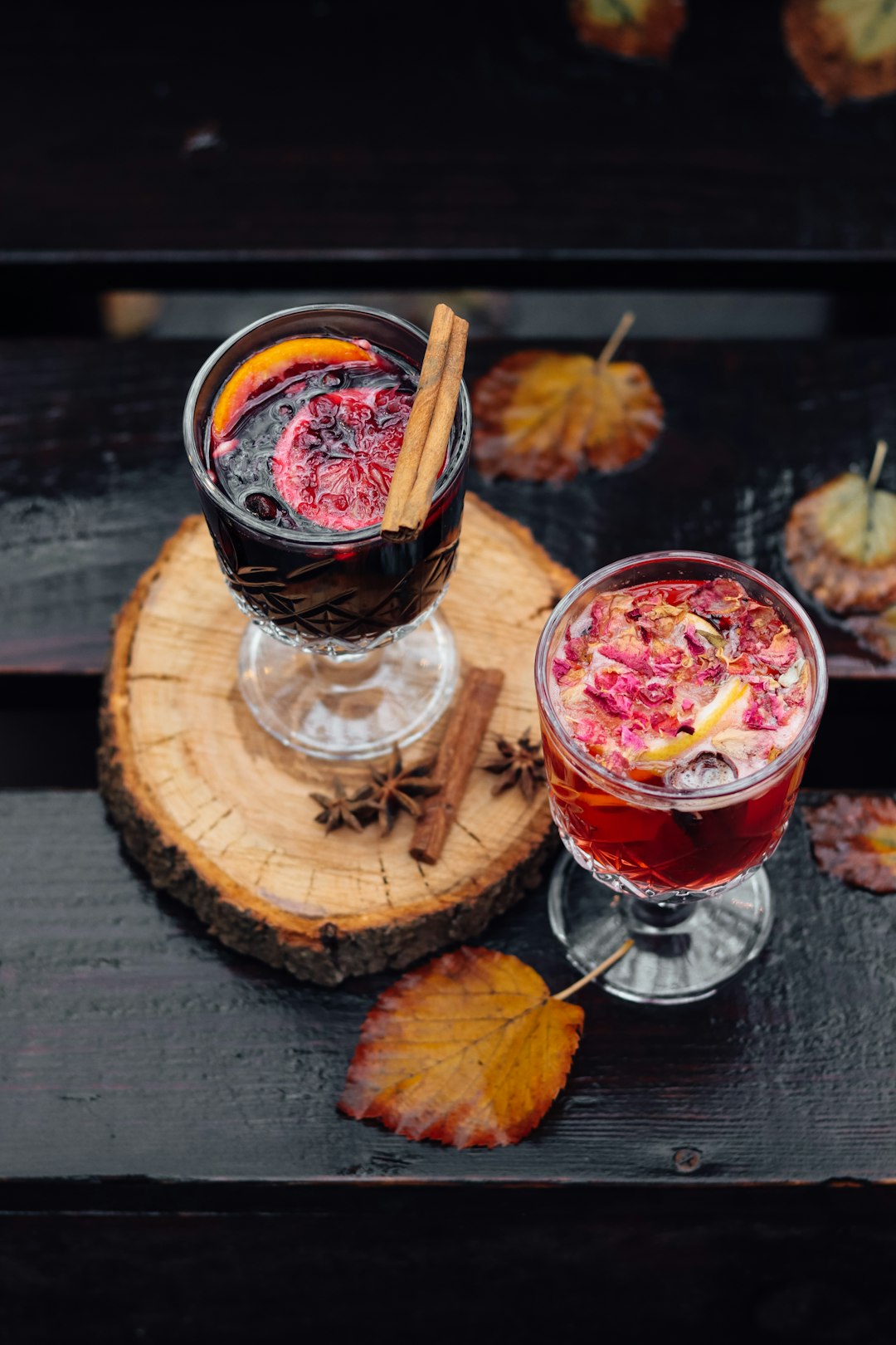 clear drinking glass with red liquid on brown wooden round tray