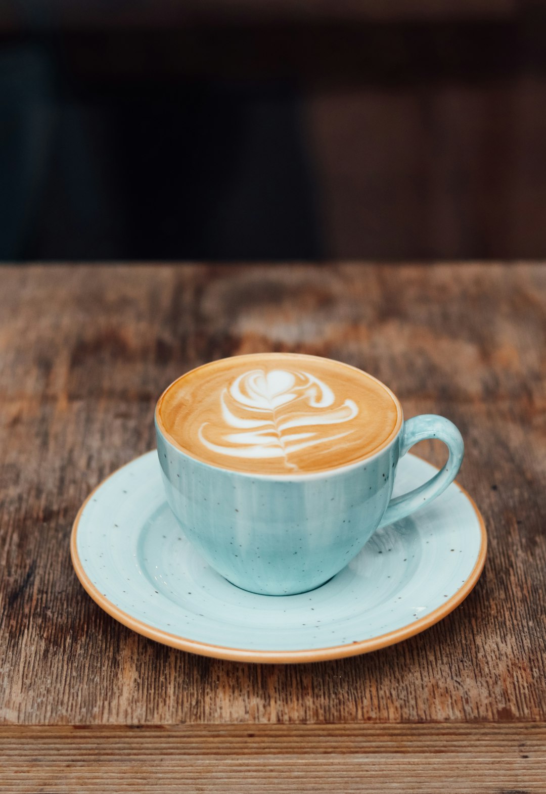 white ceramic cup with saucer on brown wooden table