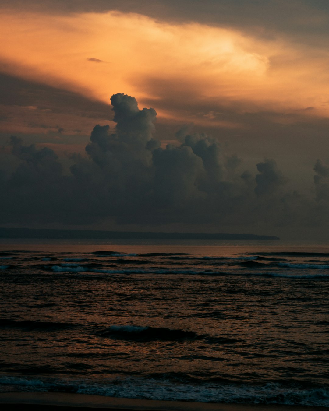 sea waves crashing on shore during sunset