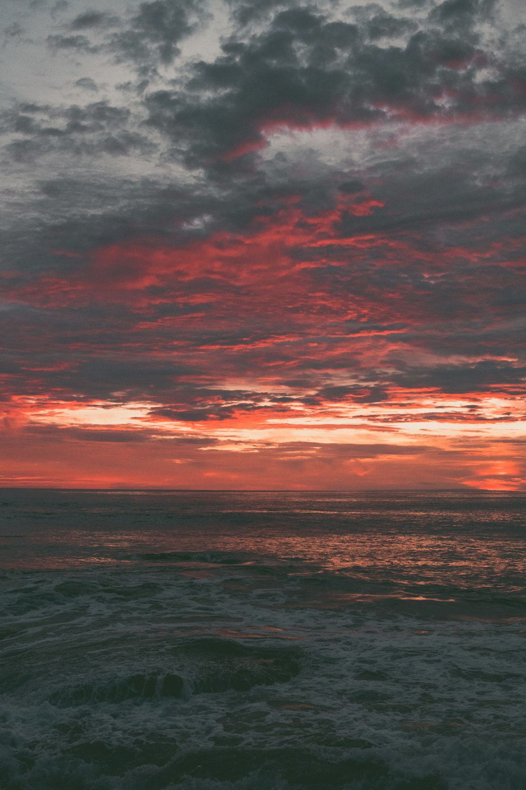 body of water under cloudy sky during sunset