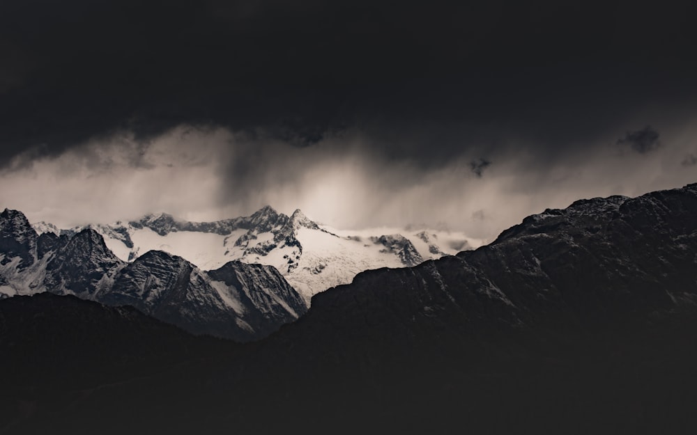 snow covered mountain under cloudy sky