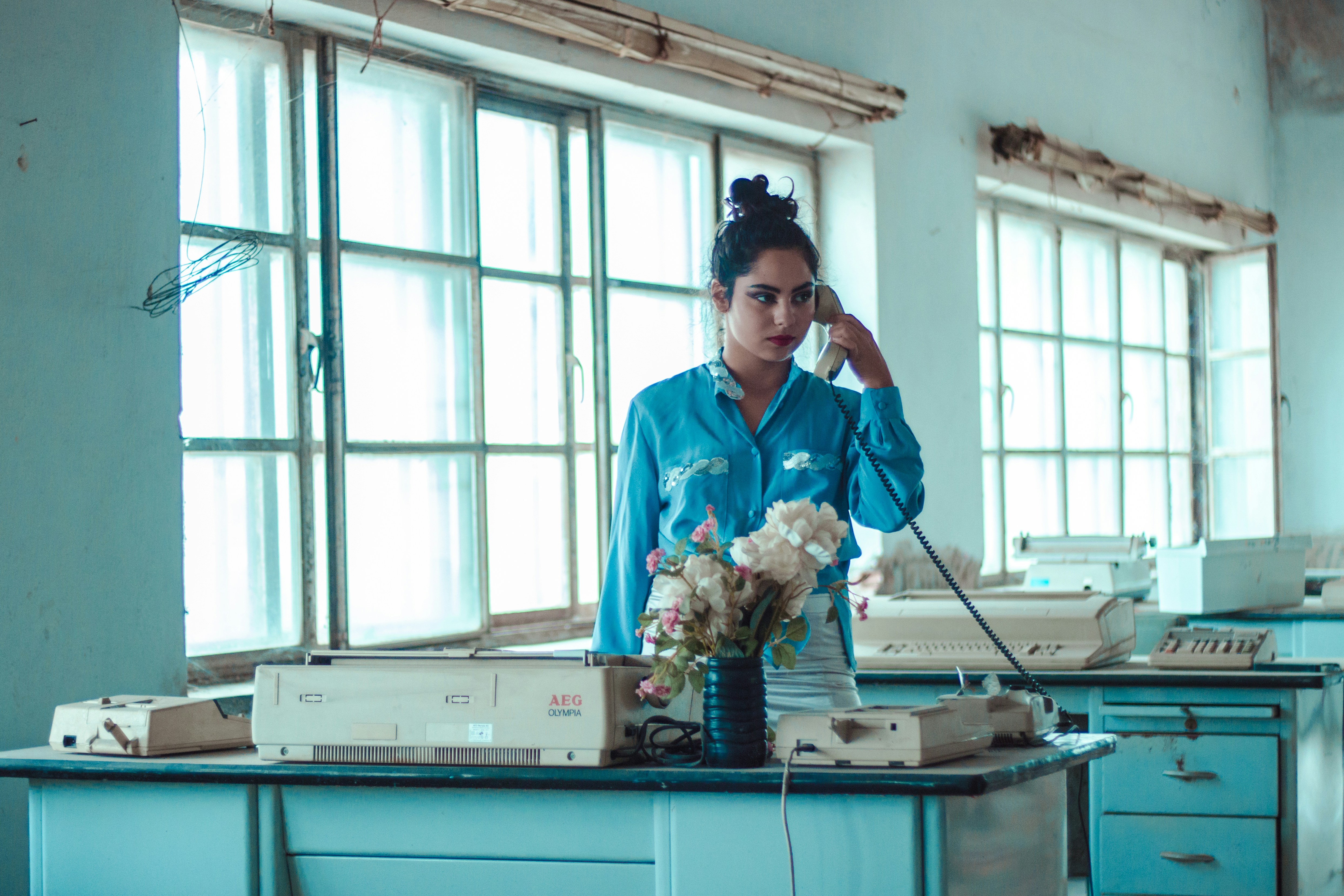 a woman in a blue shirt standing in a room