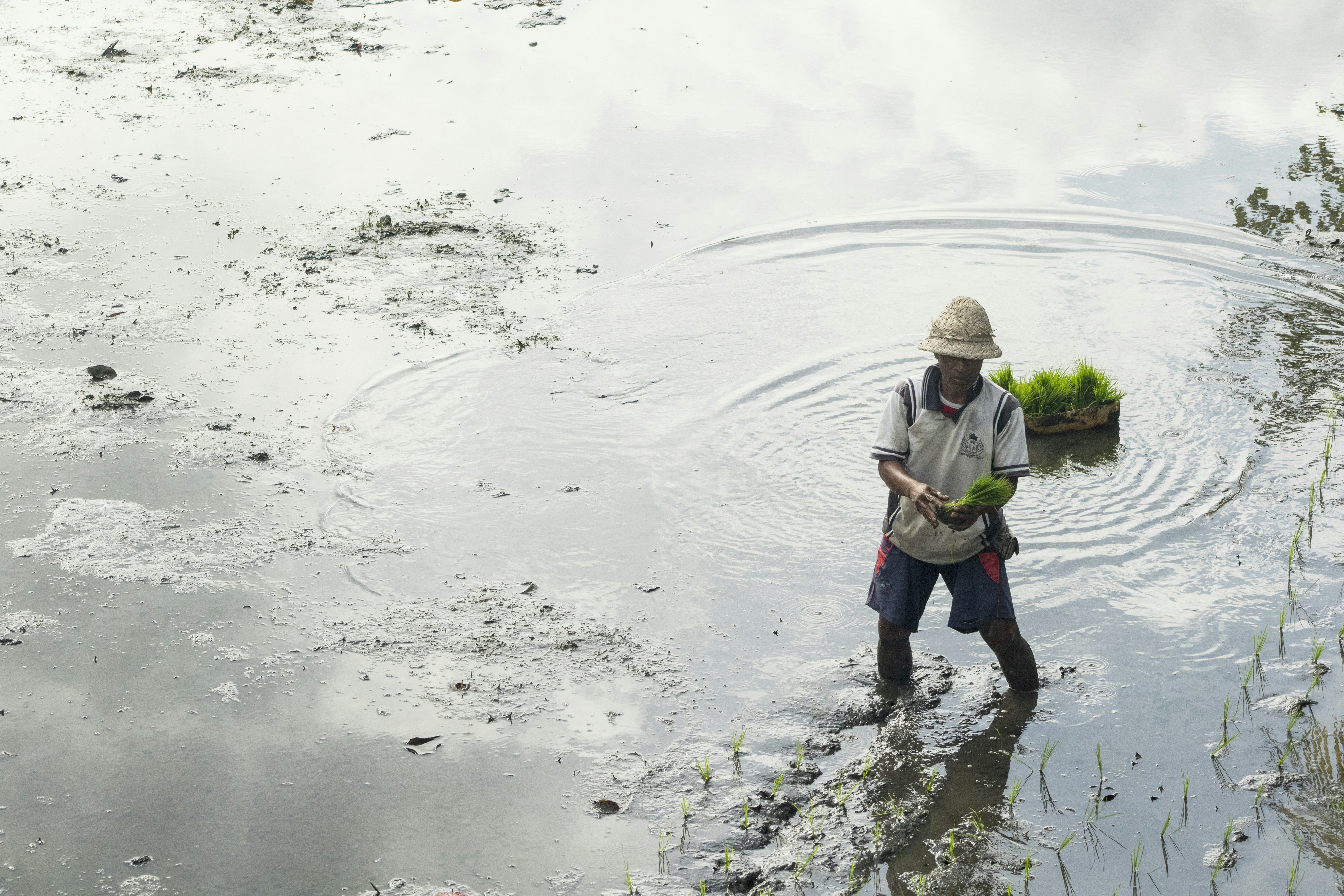 uomo in giacca verde e pantaloni neri che pesca sul fiume durante il giorno