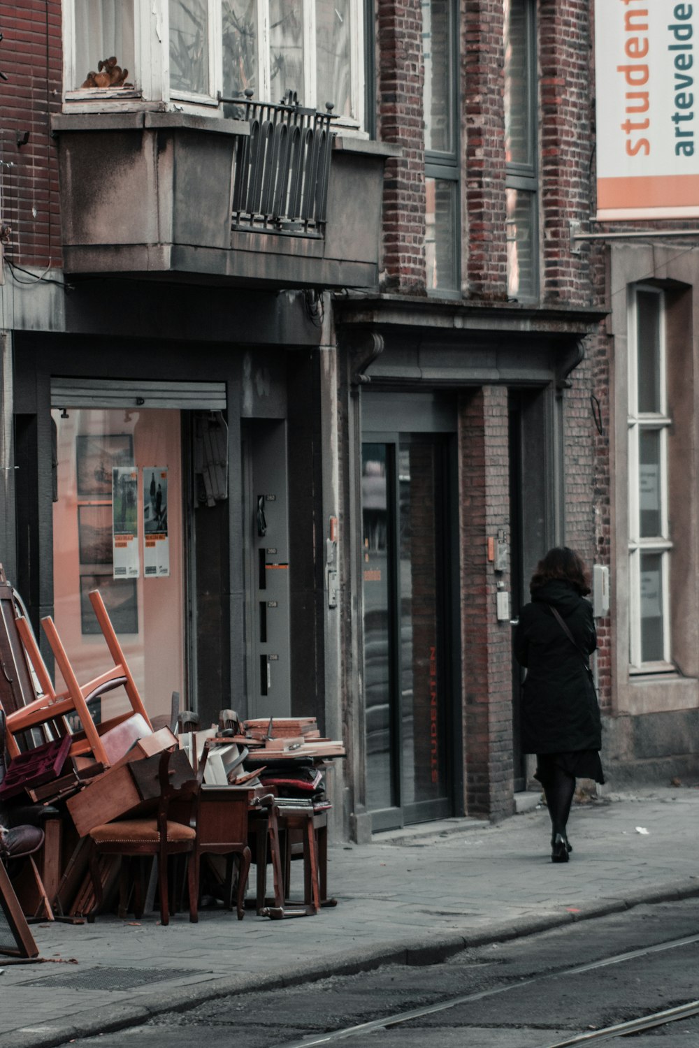 man in black coat walking on sidewalk during daytime