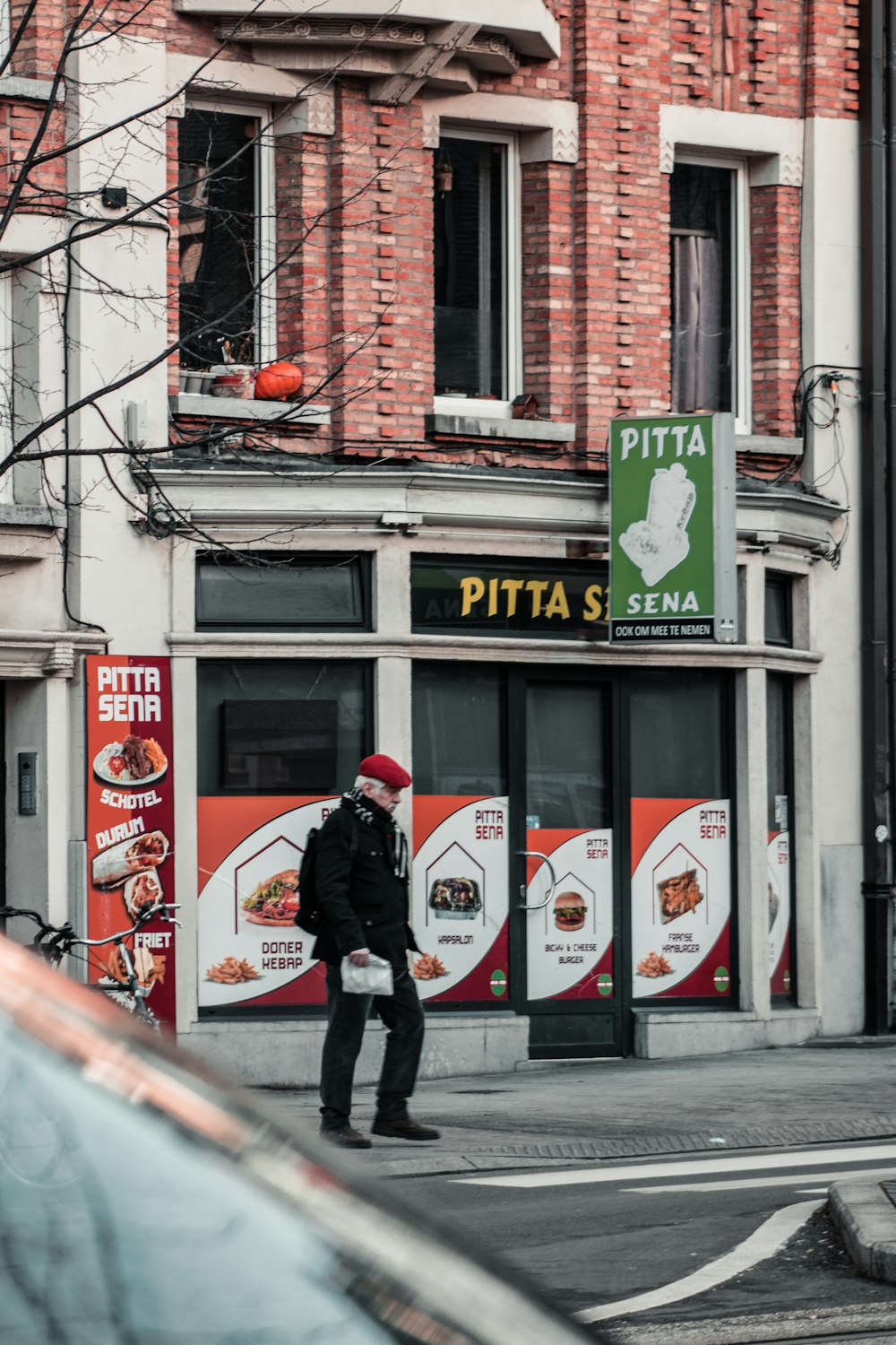 man in black jacket walking on sidewalk during daytime