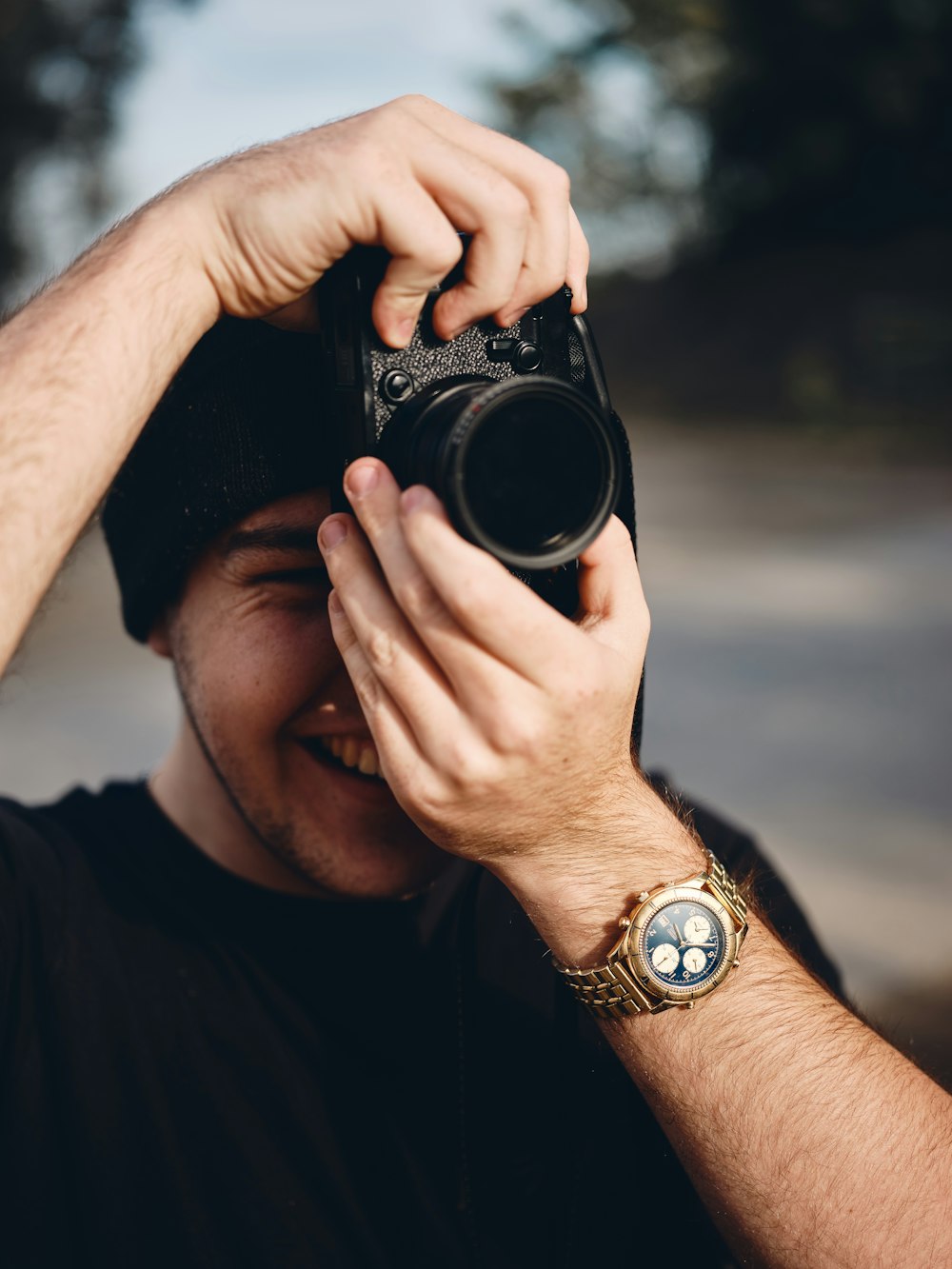 man in black shirt holding black dslr camera