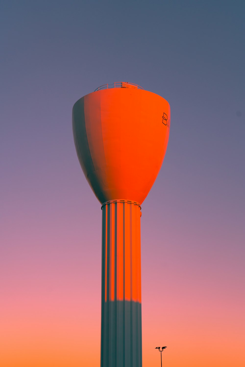 昼間の青空の下でオレンジ色の熱気球