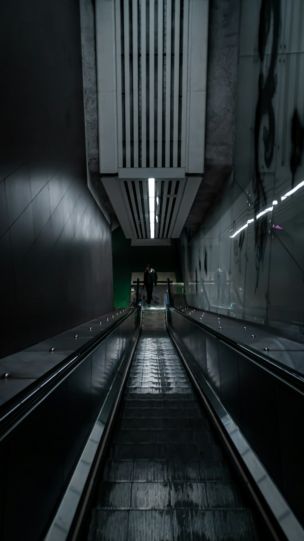 person in black jacket walking on tunnel