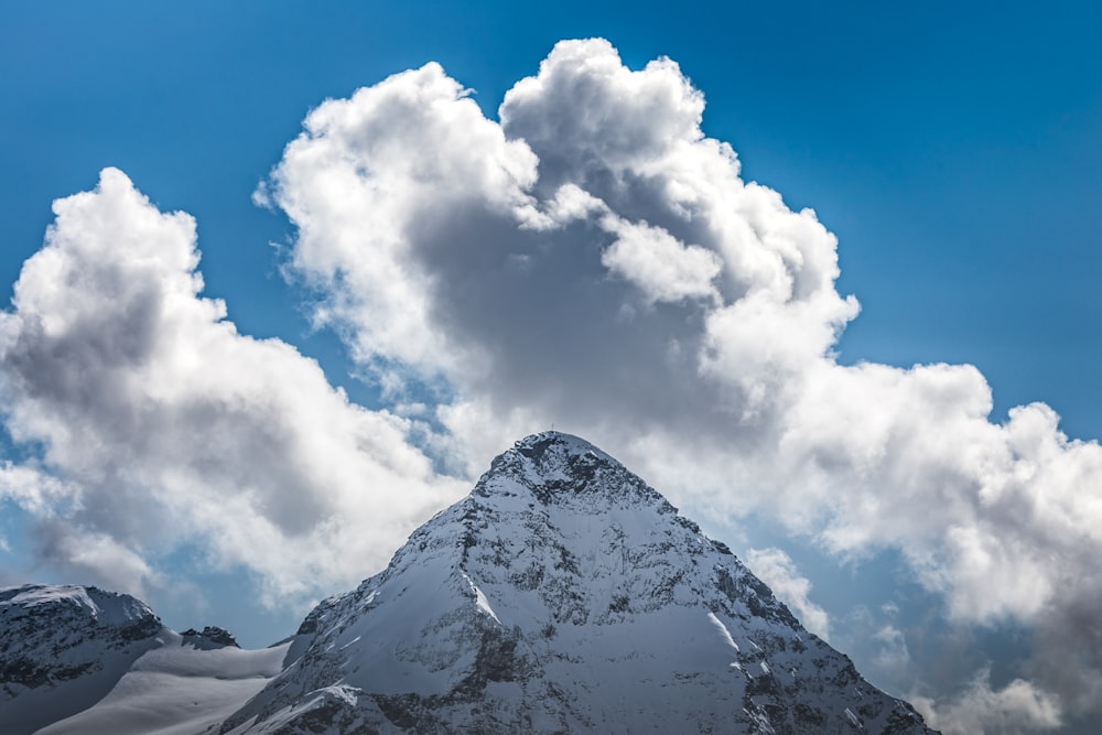 white clouds over snow covered mountain