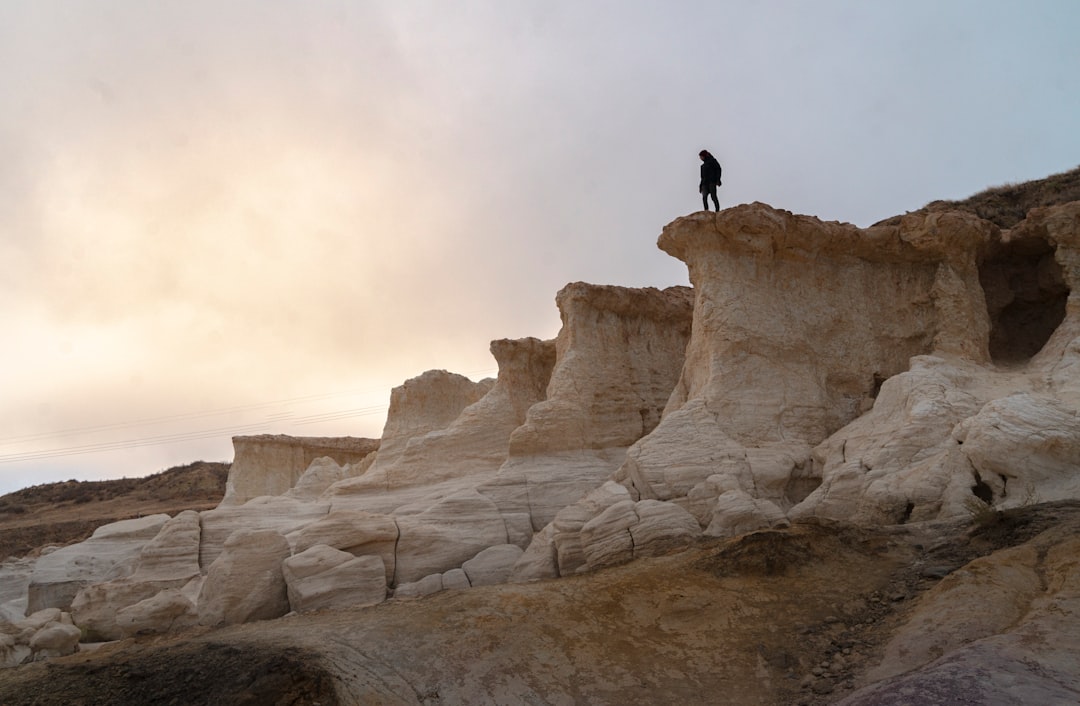 person standing on rock formation during daytime