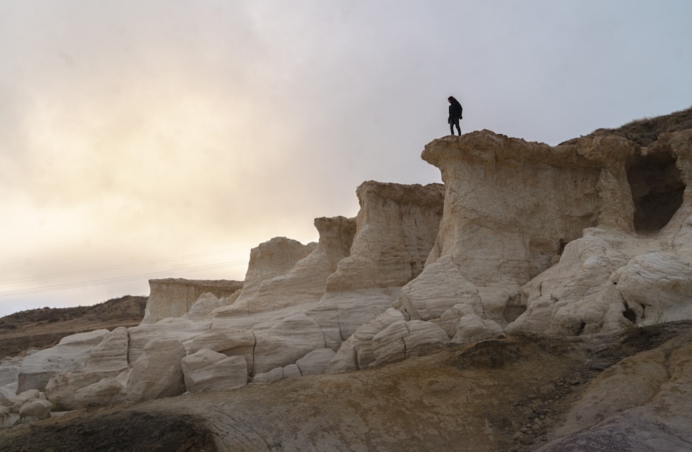 person standing on rock formation during daytime