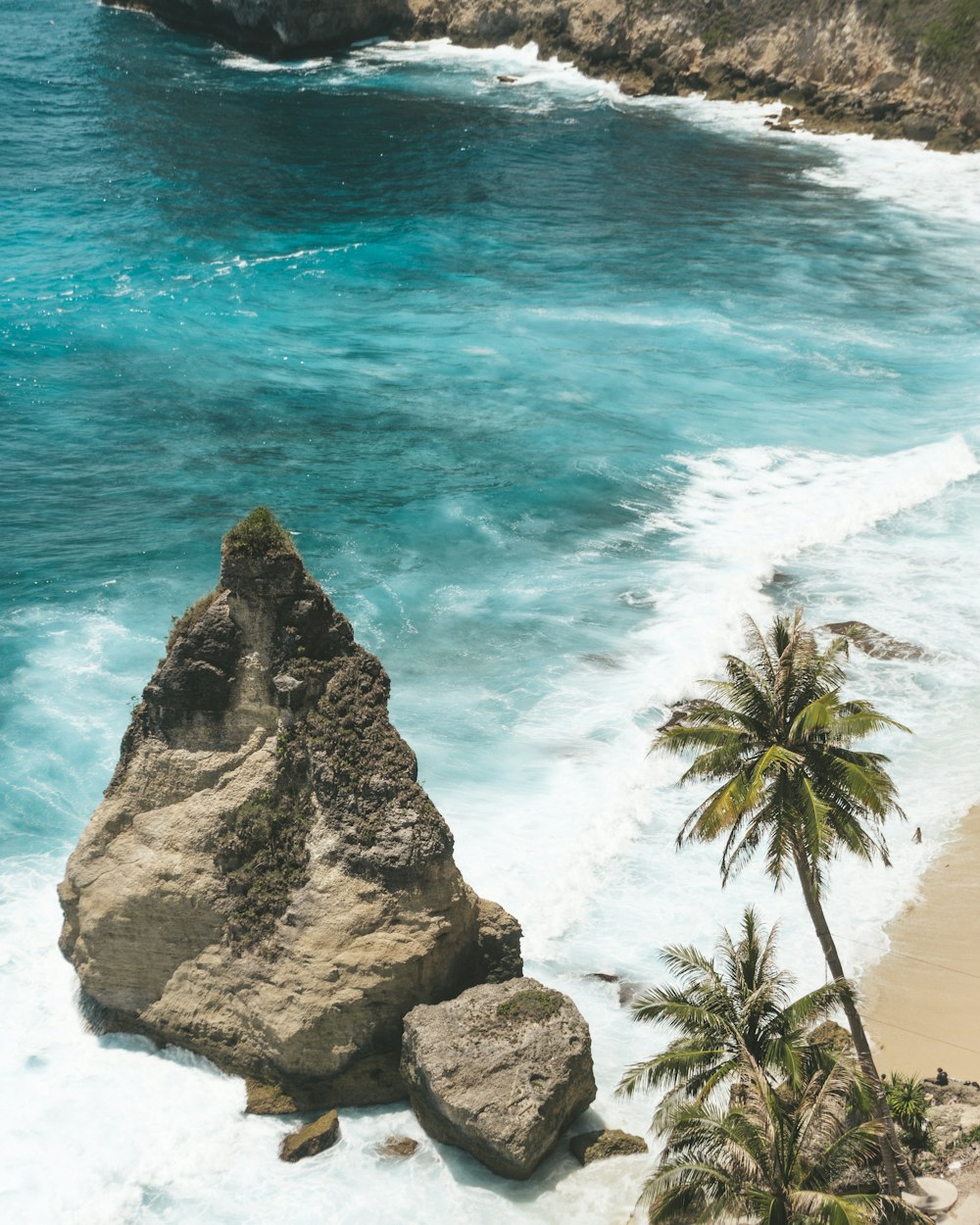 Formación rocosa marrón junto al mar azul durante el día