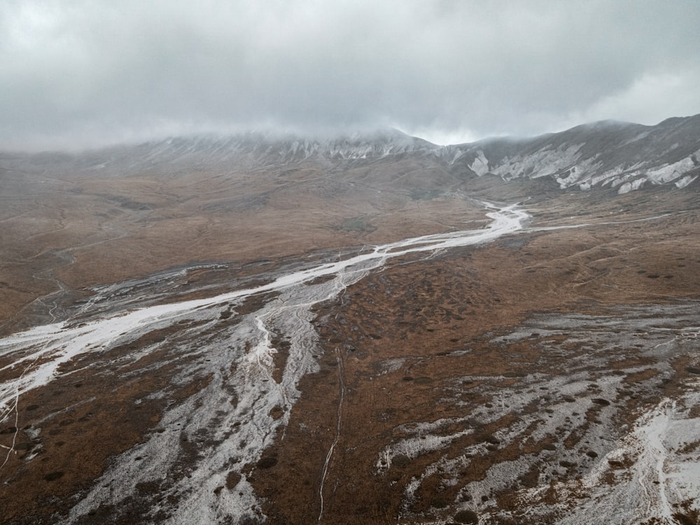 montagne marroni e bianche sotto nuvole bianche durante il giorno