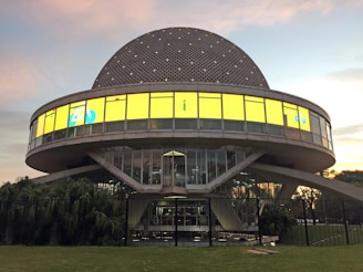 Photograph of the agency building exterior with Future Tense sign glowing in evening light