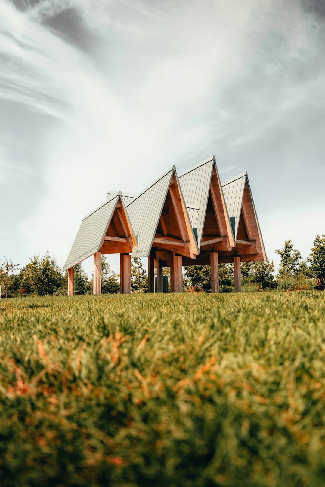 brown and gray house on green grass field under gray cloudy sky during daytime