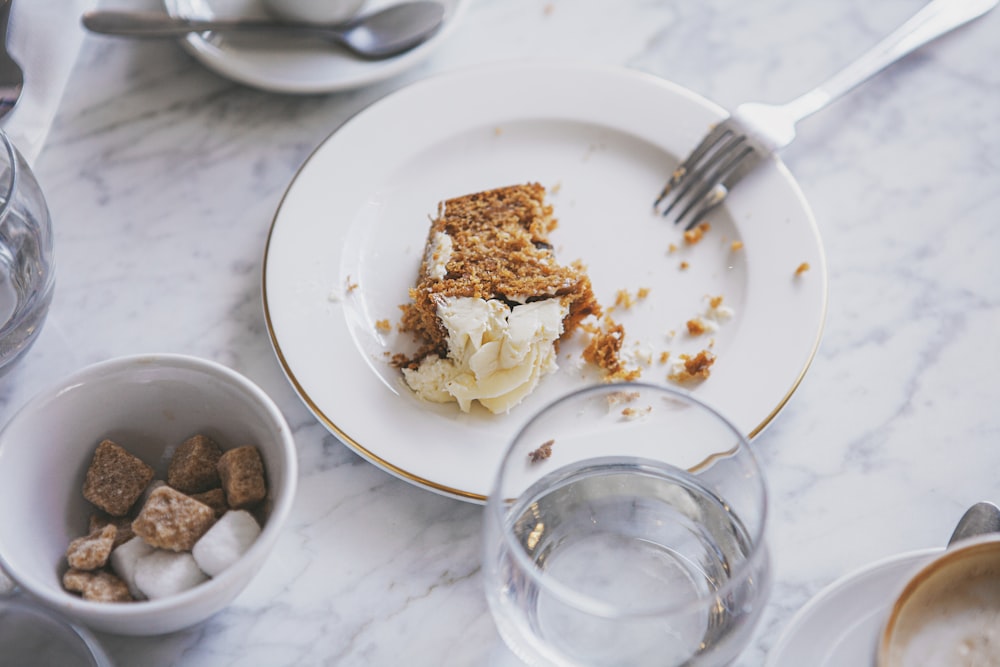 weiße Keramikplatte mit Edelstahlgabel und Löffel