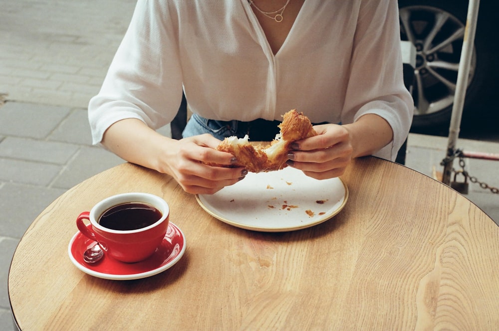 man in white dress shirt holding bread