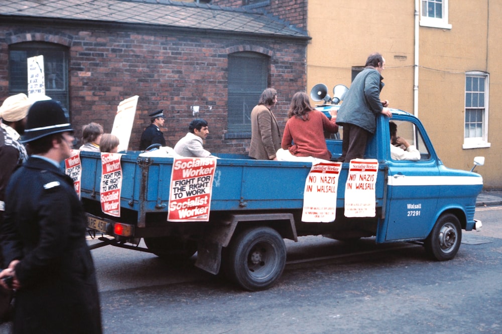 people riding on green and white truck during daytime