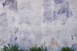 Close-up of textured wall art blending earthy colors with subtle green highlights.