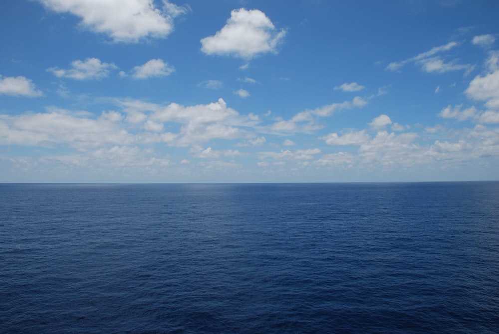 blue sea under blue sky and white clouds during daytime