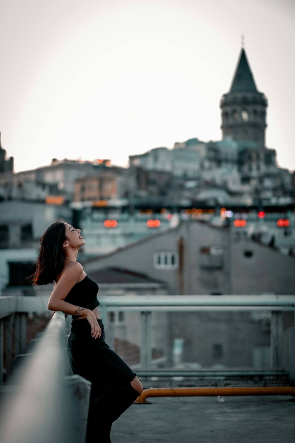 woman in black sleeveless dress standing on top of building during daytime