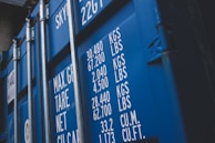 Close-up of a worker securing cargo with straps inside a shipping container.