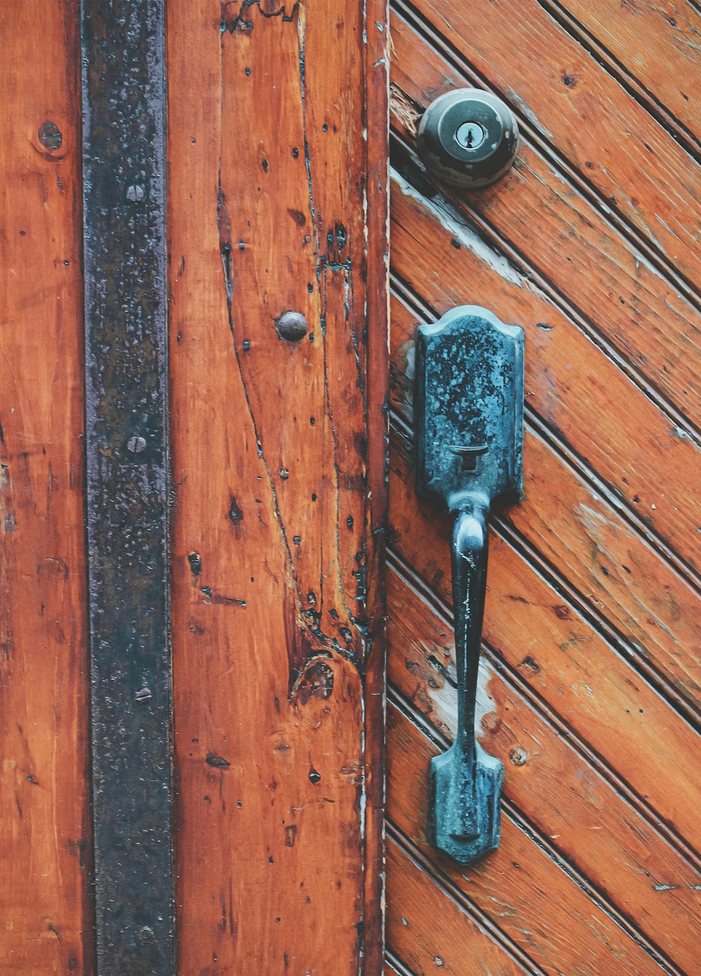 black and silver key on brown wooden surface