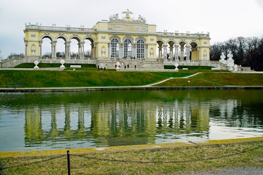 white concrete building near body of water during daytime in Schönbrunner Schloss Park Austria