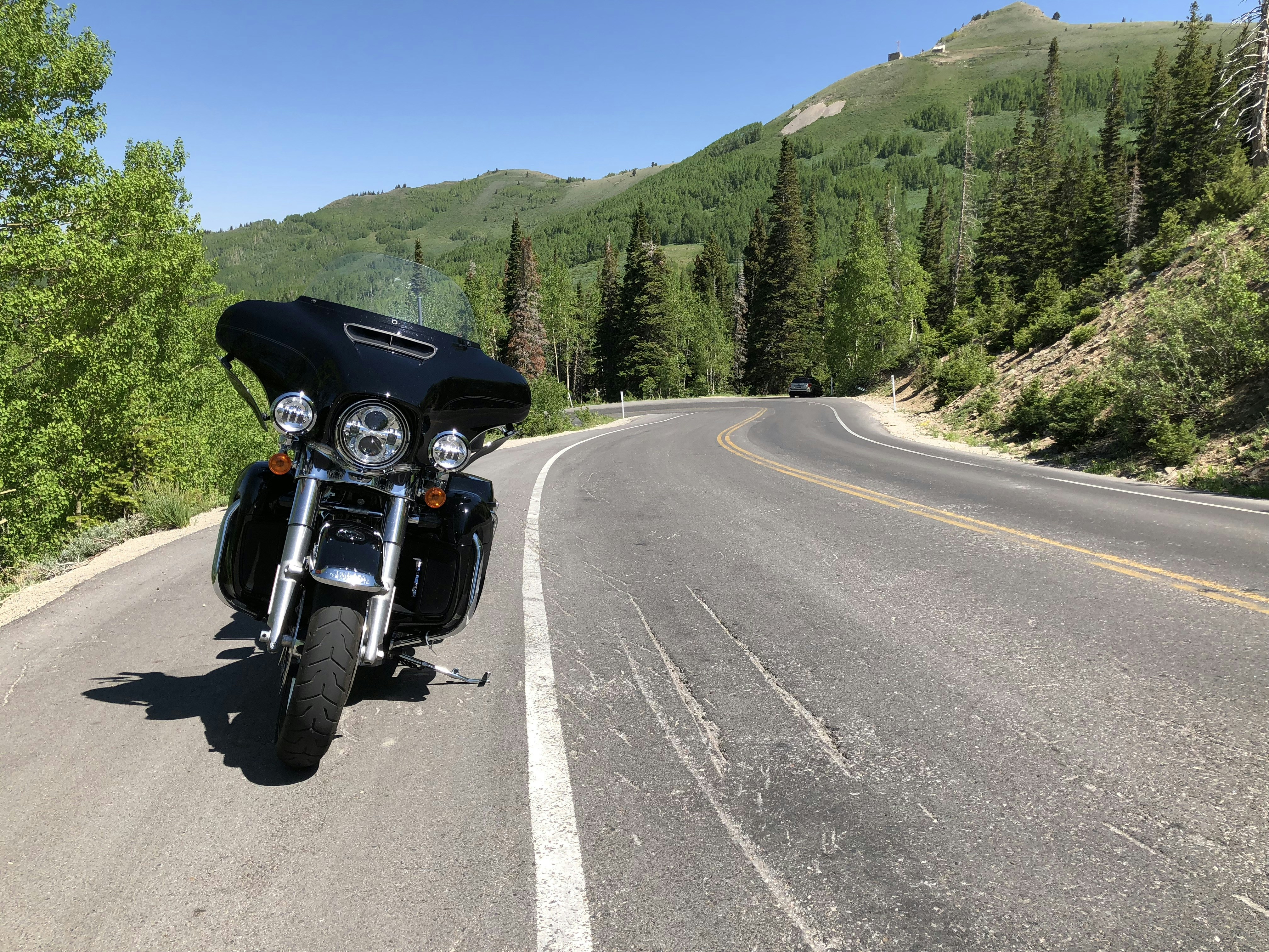 A black motorcycle parked on a winding mountain road.