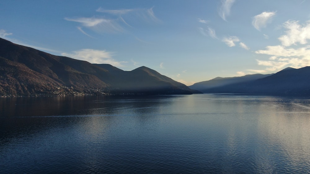 body of water near mountain under blue sky during daytime