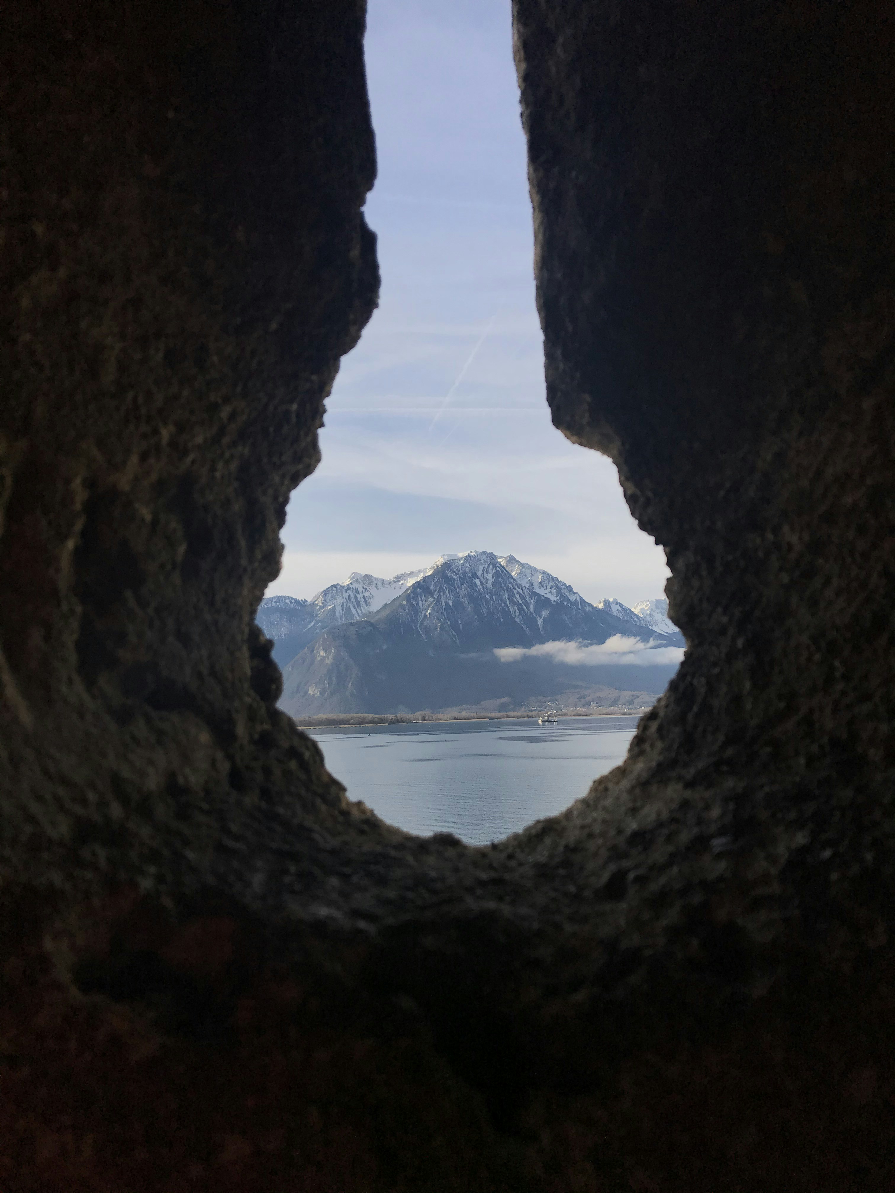 Brown cave near body of water