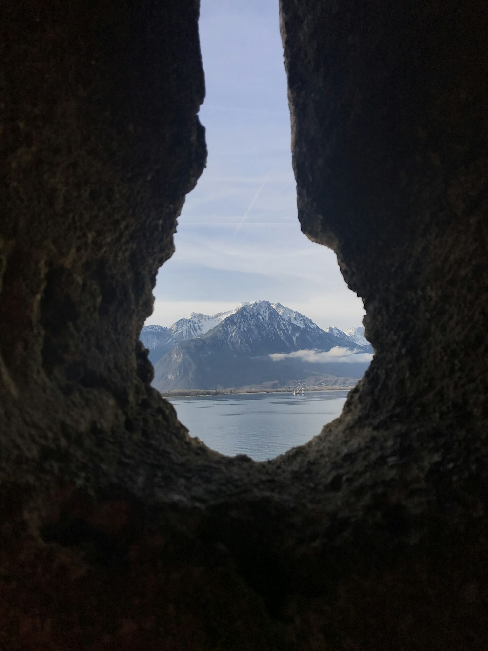 brown cave near body of water during daytime