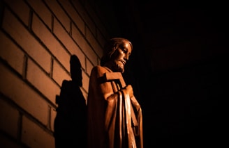 man in brown coat standing near wall