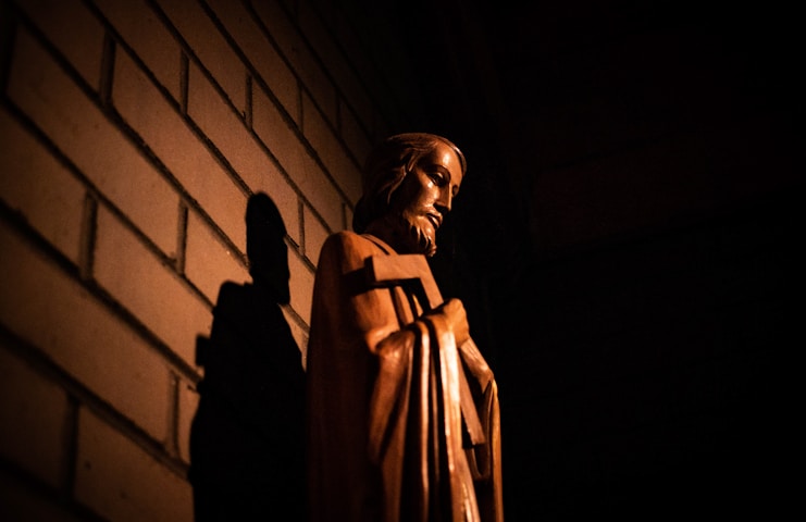 man in brown coat standing near wall