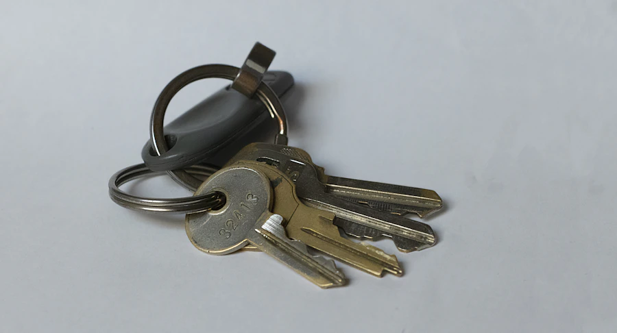 House keys resting on a wooden table beside a home sale folder