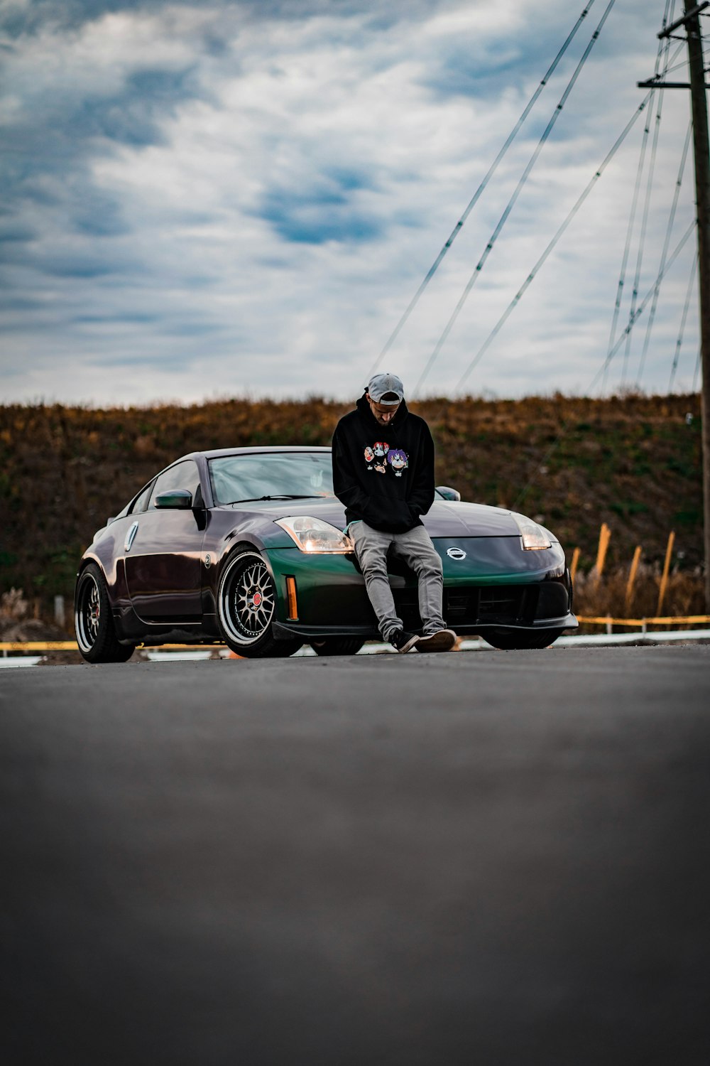 man in black jacket and black pants sitting on blue bmw coupe