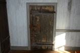 Side-by-side photo of a worn wooden door before repair and after fresh paint and new hardware installation.
