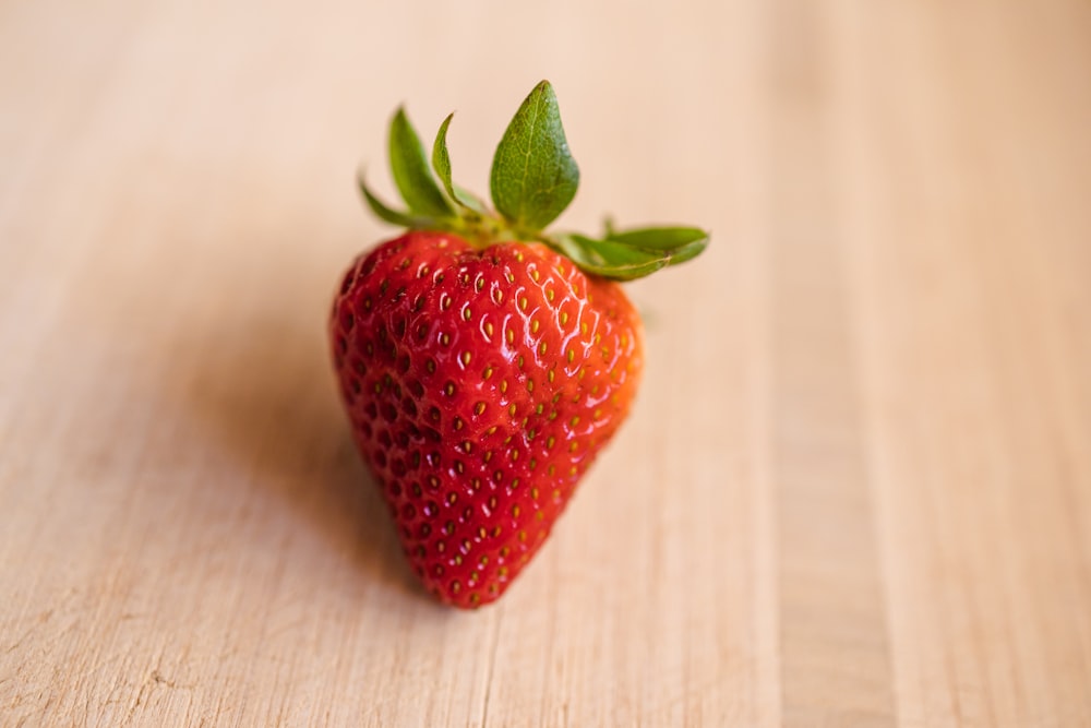 red strawberry on white textile