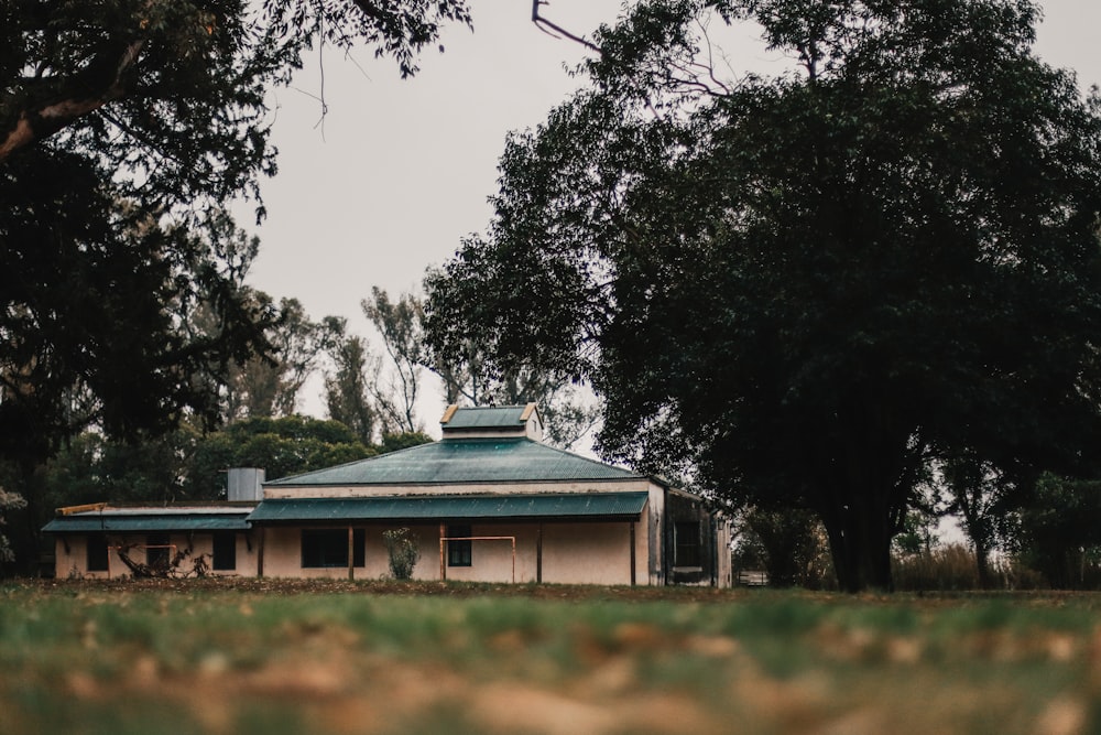 green and white house surrounded by green trees during daytime