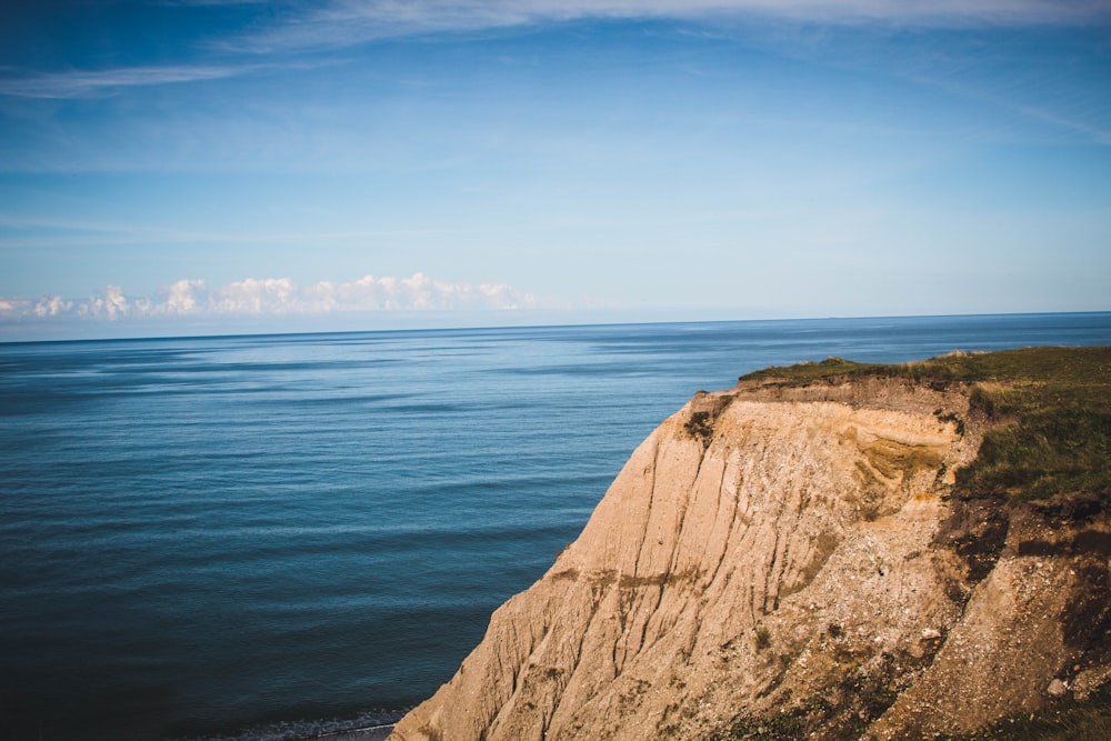 brown rock formation near body of water during daytime