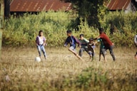 group of people playing soccer on green grass field during daytime