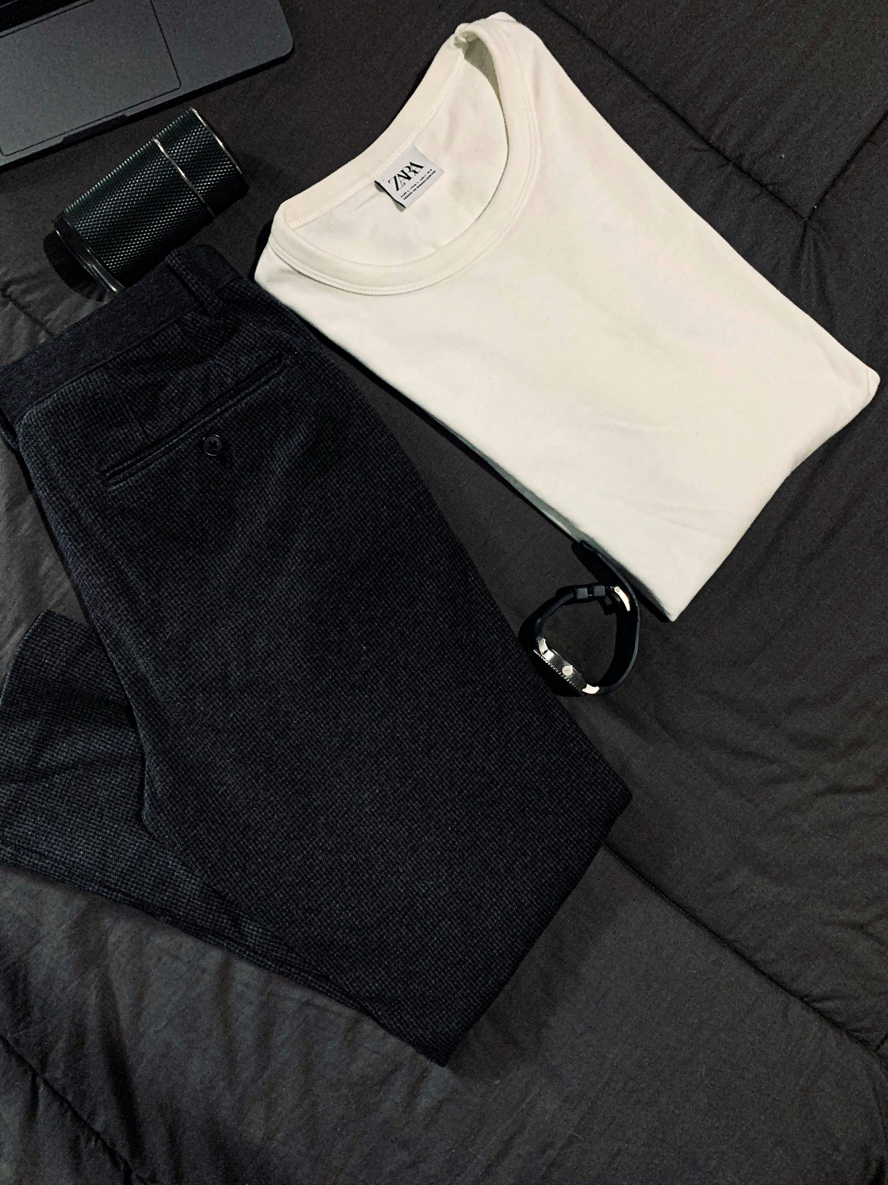 Oversized hoodie flat lay on dark surface, moody minimal styling