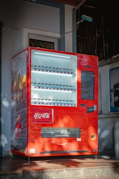 red and silver coca cola vending machine